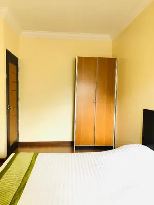 a bedroom with a bed and a wooden cabinet at Hotel Chua Gin in Cameron Highlands