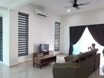 a living room with a couch and a tv at Greenville Homestay in Balik Pulau