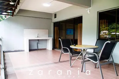 a table and chairs in a room with a fireplace at Zarania Hillhomes Cameron Highlands in Cameron Highlands
