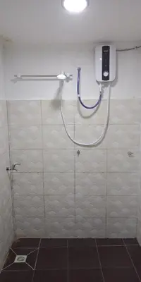 a shower in a bathroom with a blue hose at Nadrah Cottage in Bayan Lepas