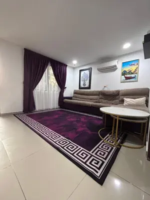 a living room with a couch and a table at Nadrah Cottage in Bayan Lepas