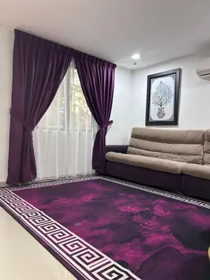 a living room with a couch and a purple rug at Nadrah Cottage in Bayan Lepas