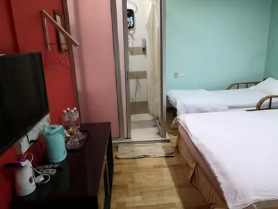 a room with two beds and a flat screen tv at Home Inn Hotel in Ipoh