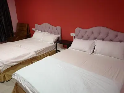 two beds sitting next to each other in a room at Home Inn Hotel in Ipoh
