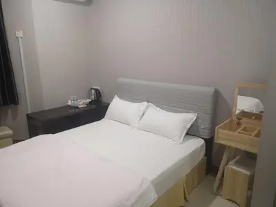 a bed with white sheets and pillows in a room at Home Inn Hotel in Ipoh