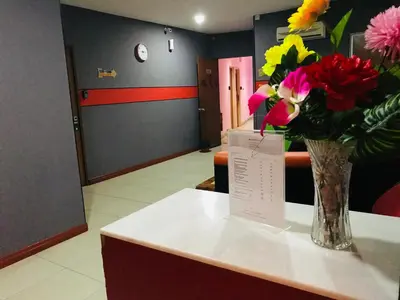 a vase of flowers on a counter in a waiting room at Home Inn Hotel in Ipoh