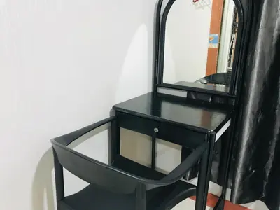 a black dresser with a mirror on a wall at Home Inn Hotel in Ipoh