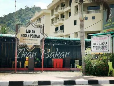 a building with signs on the side of a street at Sea & Wave #1 Coral Bay Apartment in Pangkor
