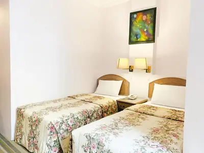 a hotel room with two beds and a telephone at Hotel Rainbow in Cameron Highlands