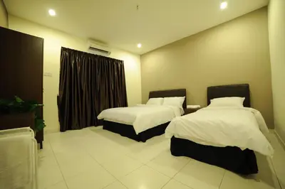 a hotel room with two beds and a window at The Osborne Apartments in Ipoh