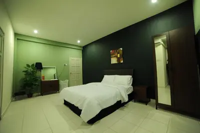 a bedroom with a large bed and a green wall at The Osborne Apartments in Ipoh