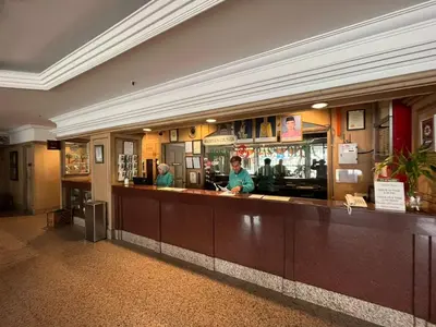 a restaurant with a bar with people standing behind it at Hotel Rosa Passadena in Cameron Highlands