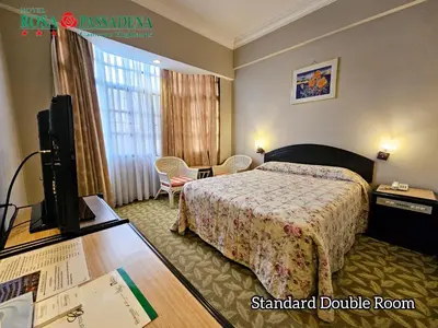 a hotel room with a bed and a flat screen tv at Hotel Rosa Passadena in Cameron Highlands