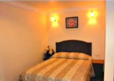 a bedroom with a bed and two lights on the wall at Hotel Remix in Cameron Highlands