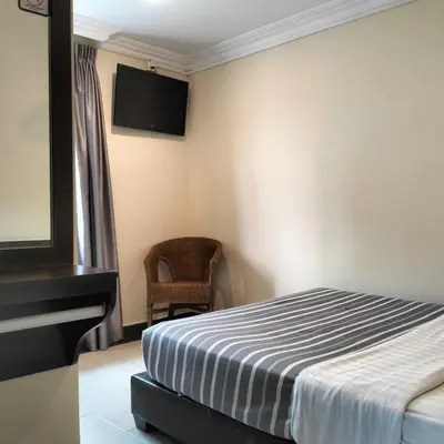 a bedroom with a bed and a tv on the wall at Hong Kong Hotel in Brinchang