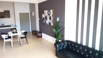 a living room with a black leather couch and a table at Misty Wonderland Cameron Next to Night Market 9 PAX in Cameron Highlands