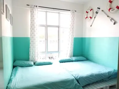 two beds in a room with a window at Blue Romance Mermaid Cameron Stay 9 pax Next to Night Market in Cameron Highlands