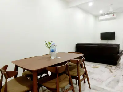 a wooden table with chairs and a bottle of water on it at Taiping Cozy Homestay II in Taiping