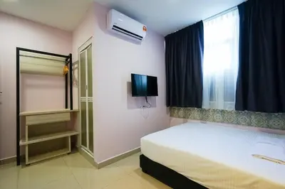 a bedroom with a bed and a tv and a window at Grand FC Hotel in George Town