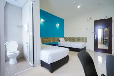 a hotel room with two beds and a toilet at Grand FC Hotel in George Town