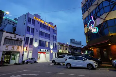 a city street with cars parked in front of a building at Grand FC Hotel in George Town