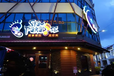 a restaurant with a sign on the side of a building at Grand FC Hotel in George Town