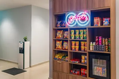 a book shelf with food and a refrigerator in a room at Tune Hotel Georgetown Penang in George Town