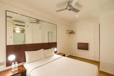a bedroom with a white bed and a mirror at Tune Hotel Georgetown Penang in George Town