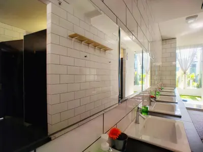 a bathroom with three sinks and a large mirror at Beds In Garden Hostel in Ipoh