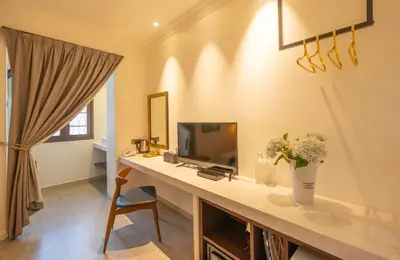 a room with a desk with a tv and flowers on it at Manhattan Residence in George Town