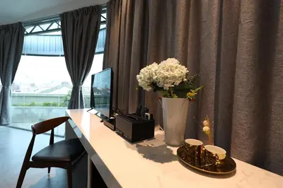 a desk with a vase of flowers and a television at Manhattan Residence in George Town