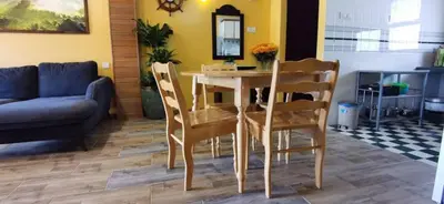 a dining table and chairs in a living room at My Home Apartment - Villa Dahlia Apartment in Cameron Highlands
