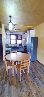 a kitchen with a wooden table and a wooden floor at My Home Apartment - Villa Dahlia Apartment in Cameron Highlands