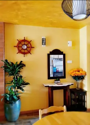 a dining room with a table and a clock on the wall at My Home Apartment - Villa Dahlia Apartment in Cameron Highlands