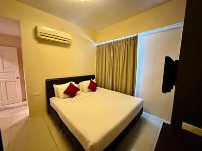 a bedroom with a bed with two red pillows at Kinta Riverfront Hotel & Suites in Ipoh