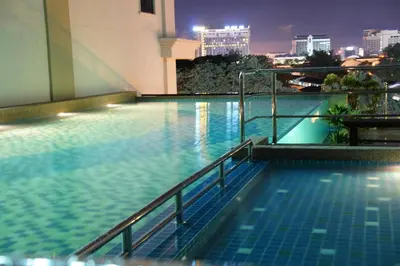 a swimming pool on the roof of a building at night at Kinta Riverfront Hotel & Suites in Ipoh