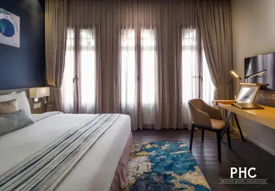 a hotel room with a bed and a desk at Bahari Parade Hotel Managed by The Ascott Limited in George Town