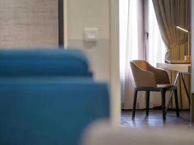 a chair in a room with a desk and a window at Bahari Parade Hotel Managed by The Ascott Limited in George Town