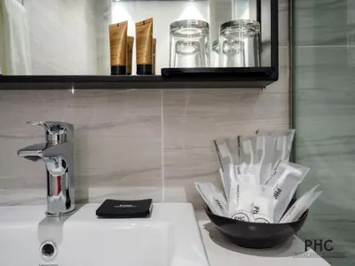 a bathroom counter with a sink and a faucet at Bahari Parade Hotel Managed by The Ascott Limited in George Town