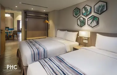 a hotel room with two beds and a dining room at Bahari Parade Hotel Managed by The Ascott Limited in George Town