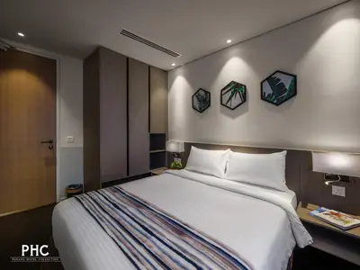a bedroom with a large bed and three pictures on the wall at Ropewalk Piazza Hotel Managed by The Ascott Limited in George Town