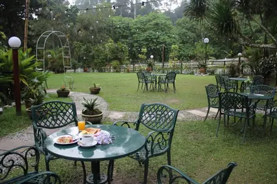 a table and chairs with a plate of food on it at Wyndham Garden Shahzan Fraser's Hill in Bukit Fraser