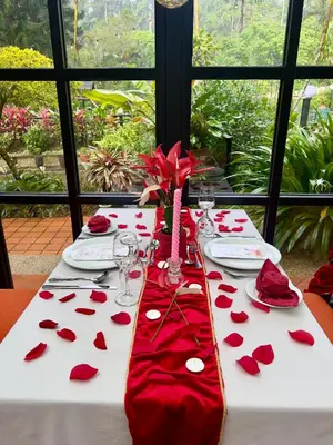 a table with red roses on a white table cloth at Wyndham Garden Shahzan Fraser's Hill in Bukit Fraser