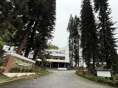 a large building with trees in front of a street at Wyndham Garden Shahzan Fraser's Hill in Bukit Fraser