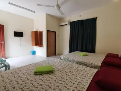a bedroom with two beds with green towels on them at Nipahmas Chalet in Pangkor