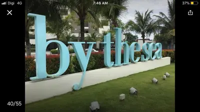 a large sign that says love in the grass at By the sea Beach BABY in Batu Ferringhi
