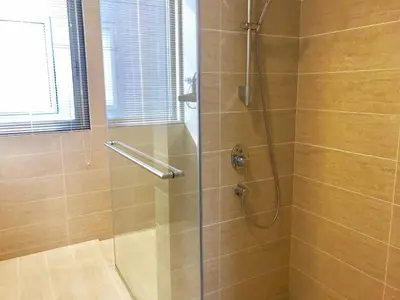 a bathroom with a shower with a glass door at By the sea Beach BABY in Batu Ferringhi