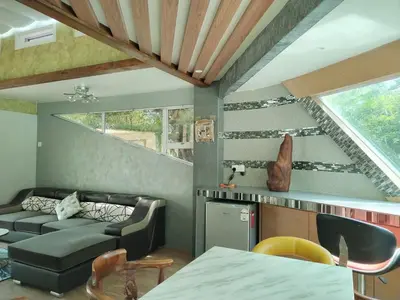 a living room with a couch and a staircase at Rocky Farm in Ipoh