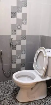 a bathroom with a toilet with the seat up at Rocky Farm in Ipoh