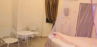 a room with chairs and a bed and a window at Rocky Farm in Ipoh